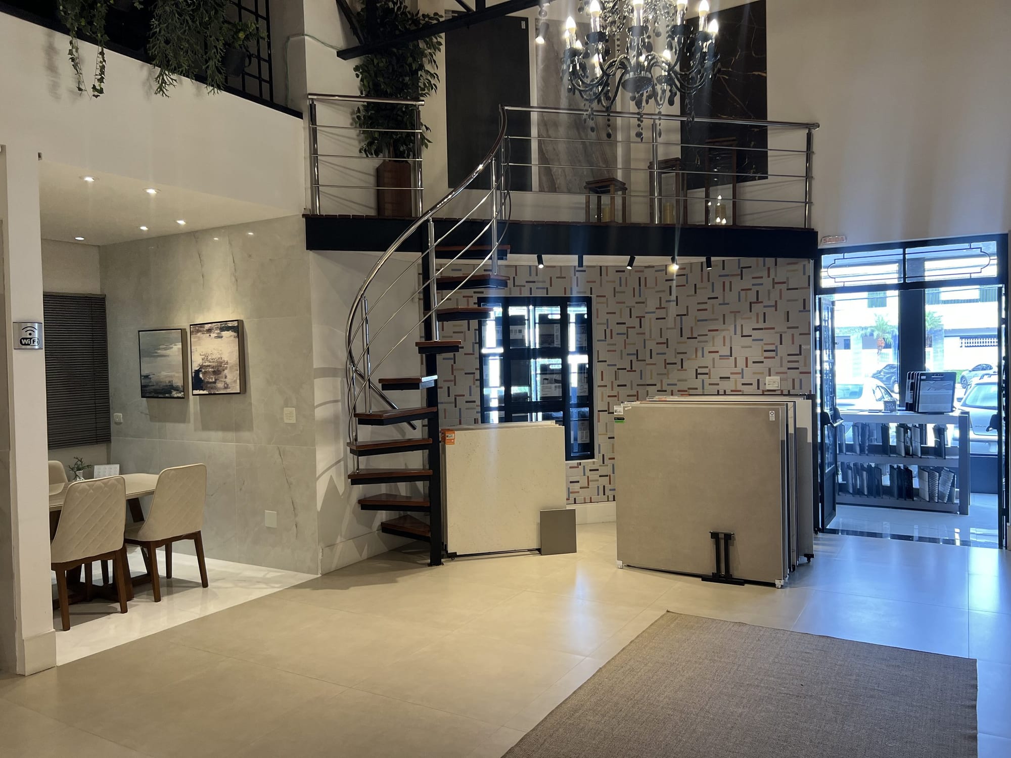 Mezanino com escada helicoidal e lustre no showroom
